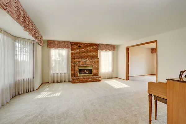 Empty living room interior in light tones with brick fireplace. — Stock Photo, Image