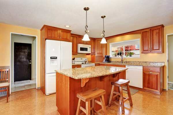 Интерьер кухни с островом, деревянными шкафами и гранитной столешницей
.