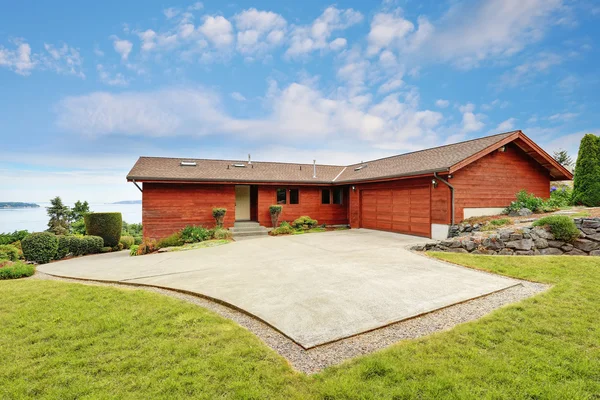 Achtertuin huis met houten paneel trim, garage en oprit. — Stockfoto