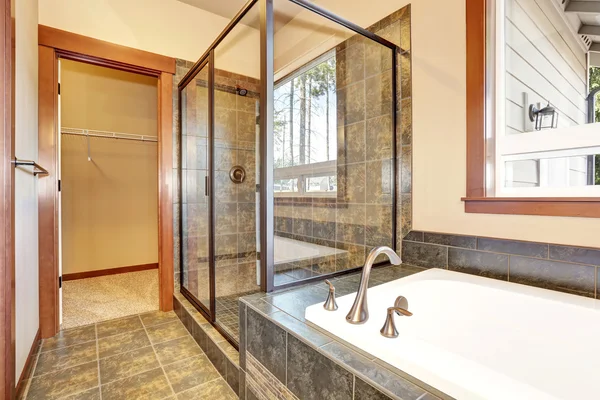 Wnętrze łazienki z marmurowymi wykończonymi płytką. Widok na szklaną kabinę prysznicową — Zdjęcie stockowe