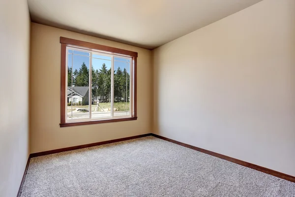 Intérieur de la chambre vide avec des murs de ton crémeux et le plancher de tapis — Photo