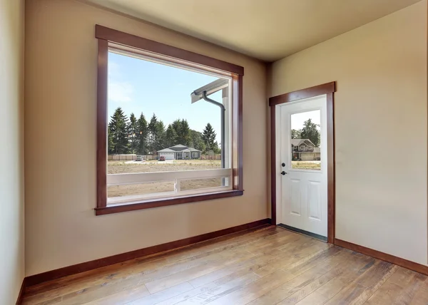 Prázdný interiér místnosti s krémovými stěnami a podlahou tvrdého dřeva — Stock fotografie