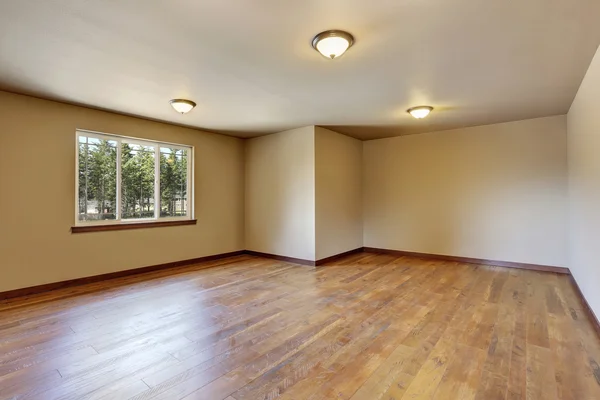 Intérieur de la chambre vide avec des murs ton crémeux et plancher de bois franc — Photo
