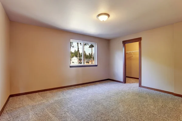 Intérieur de la chambre vide avec des murs de ton crémeux et le plancher de tapis — Photo