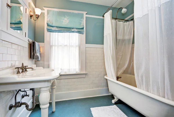 Interior do banheiro azul com parede guarnição telha branca, pia branca e banheira — Fotografia de Stock