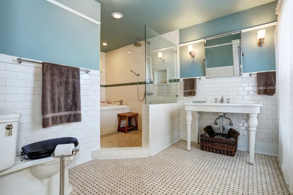 Interior del baño azul con pared de azulejos blancos, lavabo blanco y bañera —  Fotos de Stock