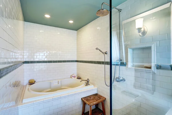 Blue bathroom interior with white tile trim wall, glass cabin shower and bath tub. — Stockfoto