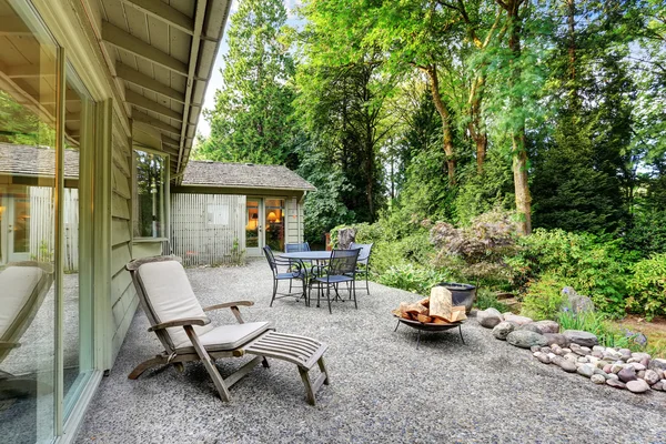 Vintage back patio with fire pit, furniture, and lots of greenery — Stock Photo, Image