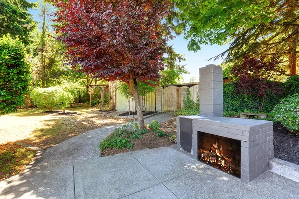 Casa patio exterior con chimenea de ladrillo azul y jardín bien cuidado — Foto de Stock