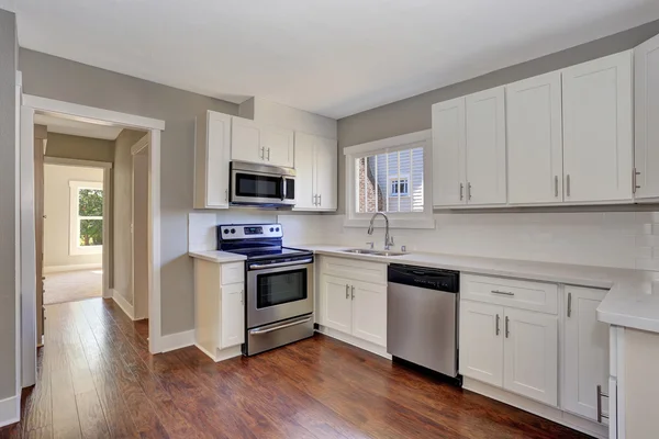 White kitchen room interior with marble counter top and hardwood floor. — Stock Photo, Image