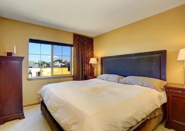 Interior del dormitorio con cama king size y cortinas marrones . — Foto de Stock
