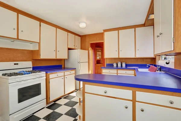 Классический интерьер кухни с белыми шкафами с синей столешницей . — стоковое фото