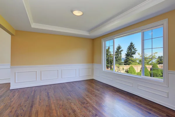 Порожній інтер'єр кімнати з жовтими стінами і дерев'яною підлогою — стокове фото