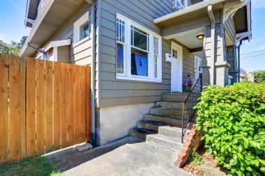 Siding evin beton zemin veranda. Ahşap çit ve yeşil çalılar