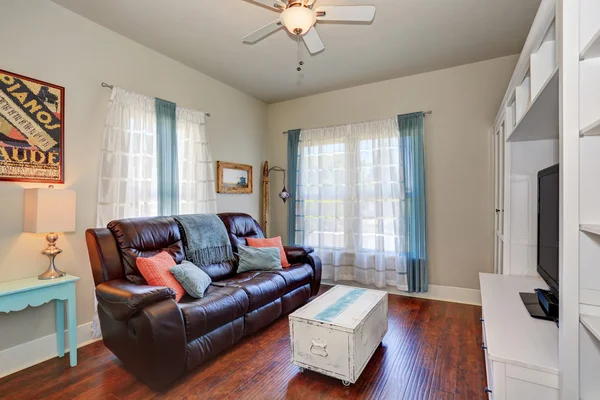 Living room interior with leather sofa and TV set.