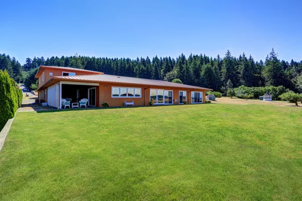 Exterior de la casa naranja. Patio trasero con césped bien cuidado . — Foto de Stock