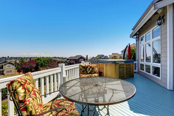 Wooden walkout deck with outdoor settees and hot tub — Stock Photo, Image