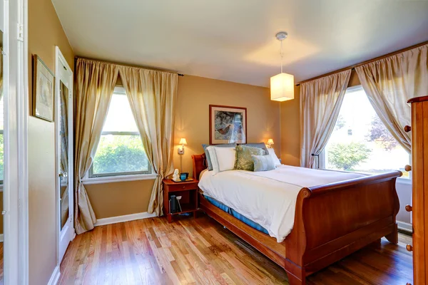 Beige Schlafzimmer mit geschnitztem Holzbett — Stockfoto