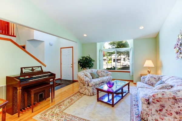 Light mint living room with floral furniture and piano — Stock Photo, Image