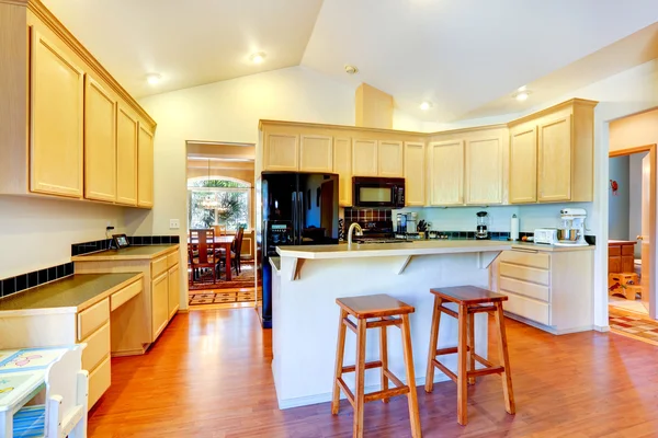 Ivory kitchen cabinets with black appliances — Stock Photo, Image