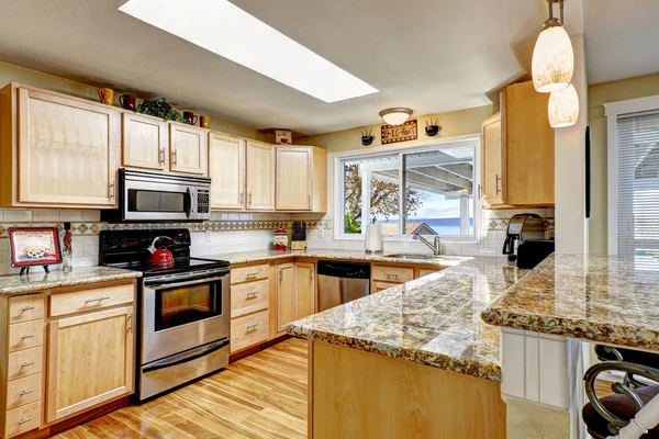Ljust kök med granit toppar och takfönster — Stockfoto