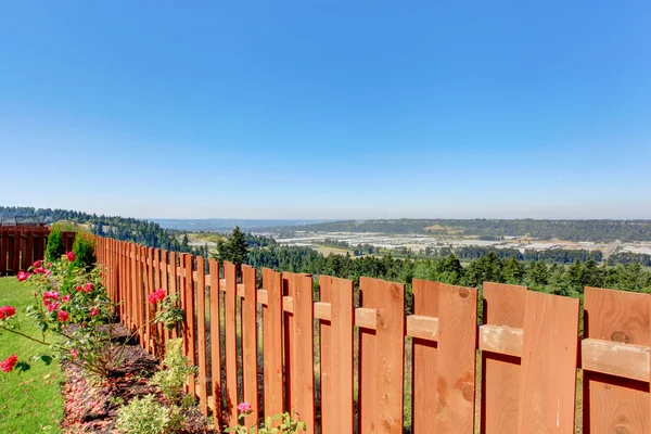 Hermosa vista al campo. Valla de madera y flores florecientes — Foto de Stock