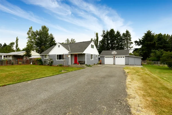Grijs huis met witte trim en rode deur — Stockfoto