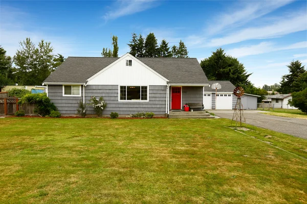 Grijs huis met witte trim en rode deur — Stockfoto