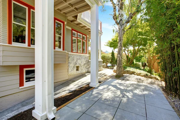 Huis buitenkant met oranje trim en dek kolommen — Stockfoto