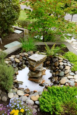 Ideas for landscaping home garden. Fountain with rocks clipart