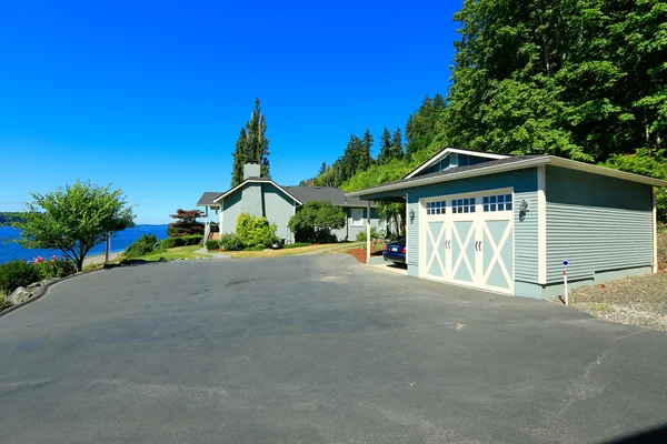 Huis met water vooraanzicht, grote oprit en garage. poort orc — Stockfoto