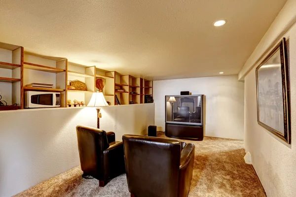 Basement room with tv and two leather chairs — Stock Photo, Image