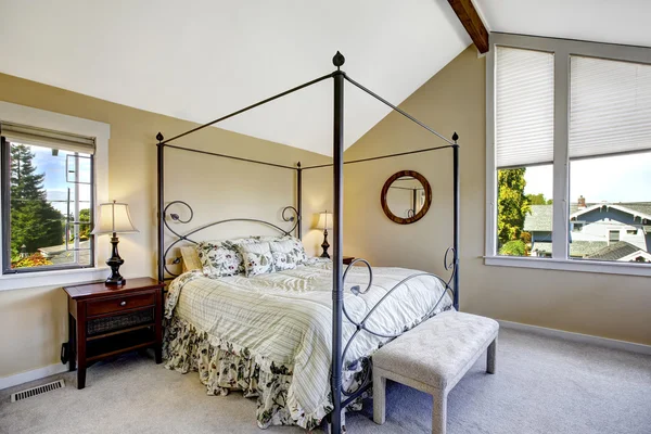 Bedroom with high iron frame bed — Stock Photo, Image