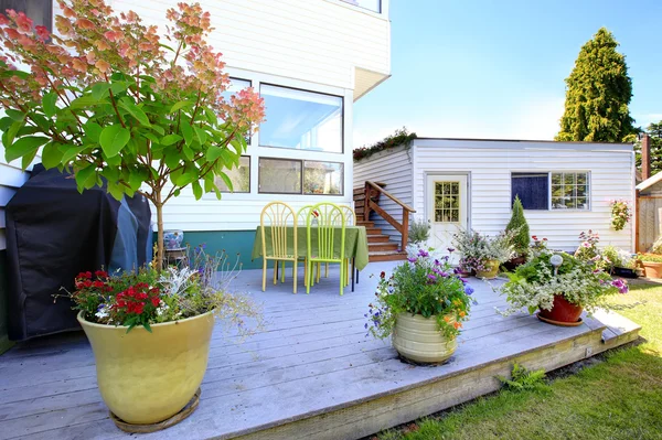 Holzterrasse mit Blumentöpfen dekoriert — Stockfoto