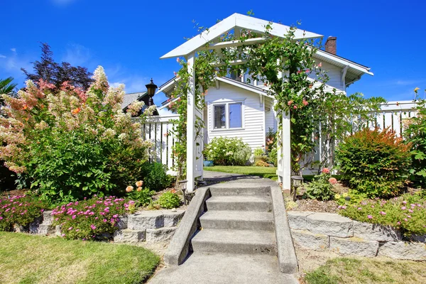 Entrada arco de madera con valla y macizo de flores — Foto de Stock