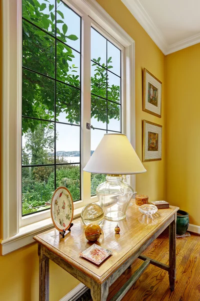 Oude houten tafel met lamp door het venster — Stockfoto