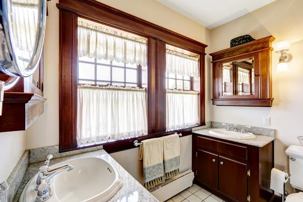 Salle de bain avec armoires brun foncé et grande fenêtre — Photo