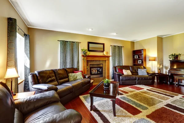 Living room interior with leather couches and fireplace — Stock Photo, Image