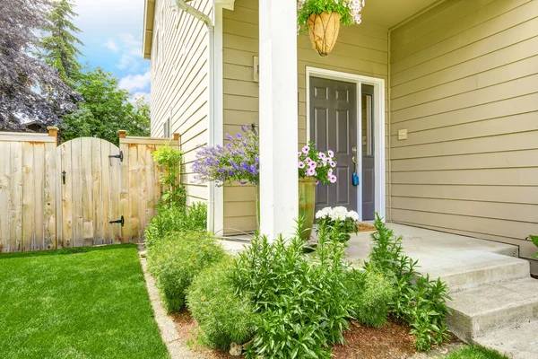 Entrance porch with flower bed and wooden fence — Stock Photo, Image