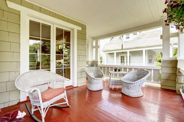 Ingang veranda met rieten stoelen en glazen deur — Stockfoto