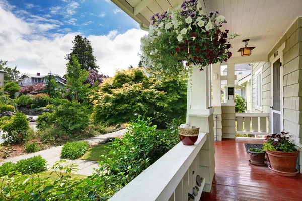 Ingang veranda met bloempotten met uitzicht op voortuin — Stockfoto