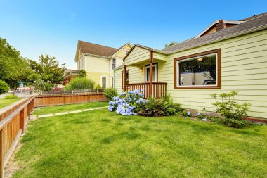 ev exterio kahverengi trim. Ön bahçede çim ve çiçek açan