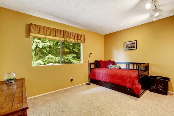 Светло-желтая спальня с черной деревянной кроватью — стоковое фото