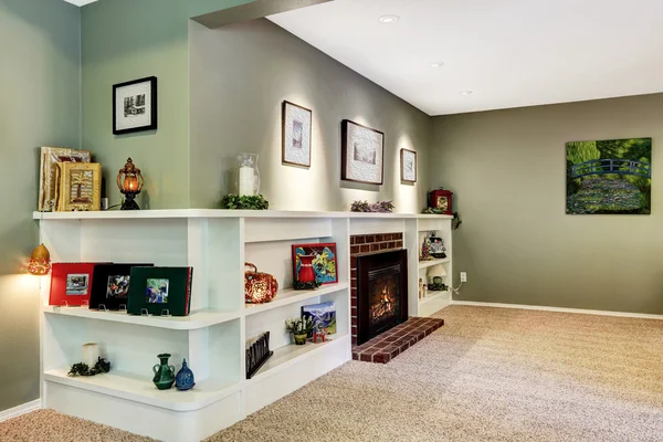Sala de estar canto com lareira e prateleiras decoradas — Fotografia de Stock