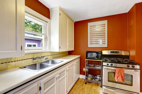 Белый кухонный шкаф с ярко-красной стеной — стоковое фото