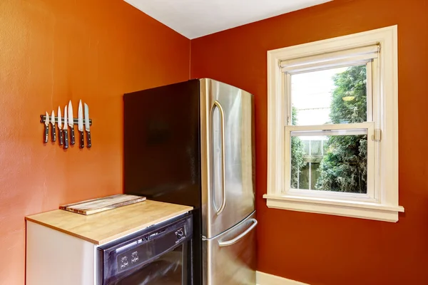 Кухня с ярко-красными стенами и стальным холодильником — стоковое фото