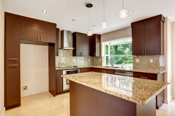 Moderne keuken kamer met mat bruin kasten en glanzende graniet — Stockfoto