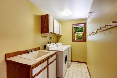 parlak sarı çamaşır odası dolapları ve lavabo