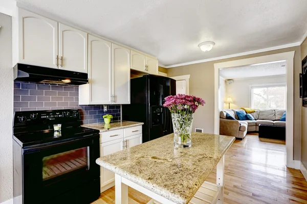 Kitchen island with granite top and flowers — Stock Photo, Image