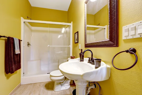 Bright yellow bathroom with glass door shower Stock Picture